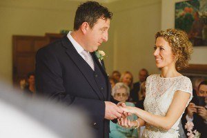 bride and groom exchanging rings at coombe lodge