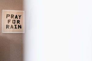 A framed sign on a textured beige wall