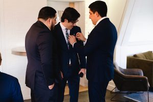 Three men in suits stand together