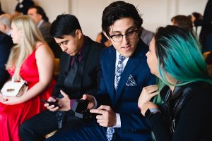A man in a blue suit holding a small black box
