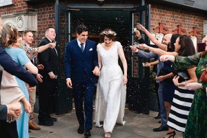 A bride and groom smile and hold hands