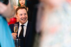 A man in a suit and tie smiles