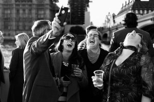 A group of people outdoors laugh and smile