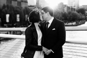 A couple in formal attire shares a kiss