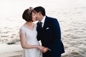 A bride in a white dress and floral headpiece smiles
