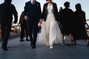 A newlywed couple walks hand-in-hand
